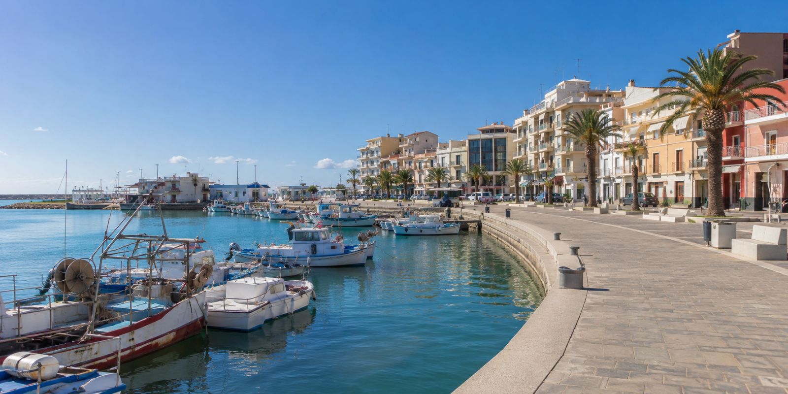 Port de Vinaròs avec bateaux de pêche, palmiers et promenade en bord de mer