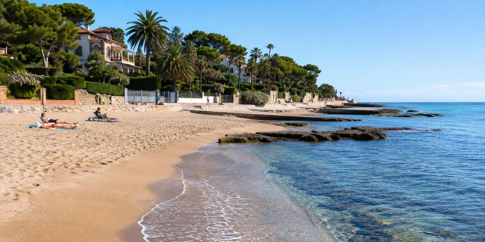 Plage élégante de Sitges avec villas méditerranéennes, pins, palmiers et mer turquoise