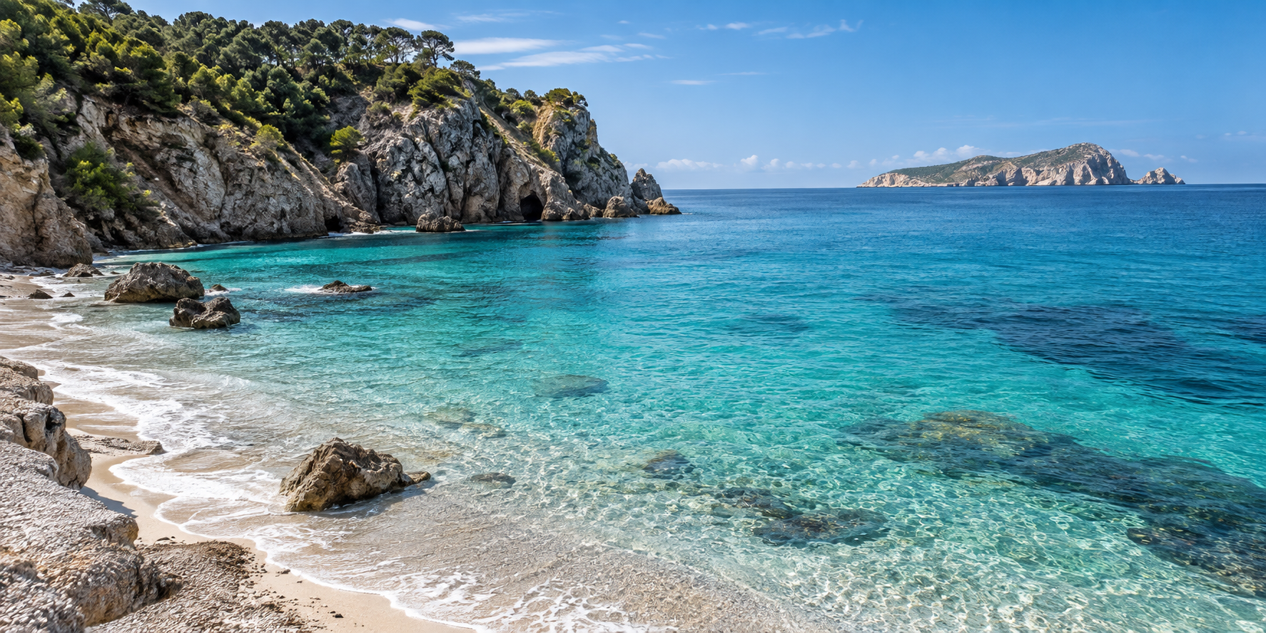 Plage naturelle d’Aigües Blanques à Ibiza avec falaises rocheuses, eau cristalline et île de Tagomago au large