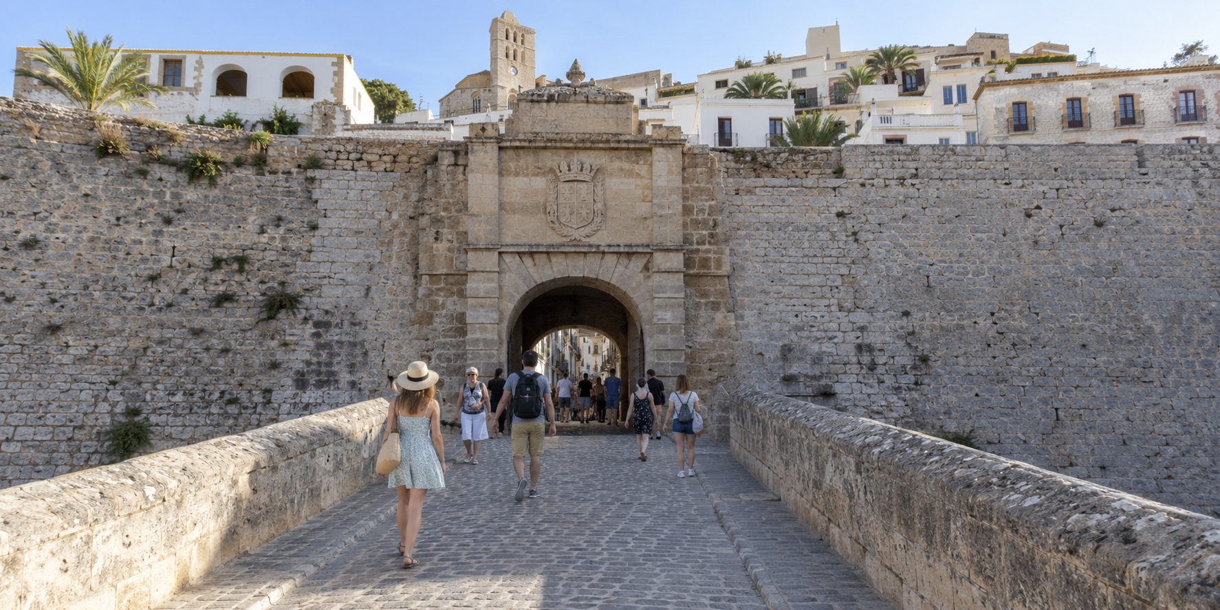 Portal de ses Taules à Dalt Vila avec entrée fortifiée, remparts en pierre et visiteurs dans la vieille ville d’Ibiza