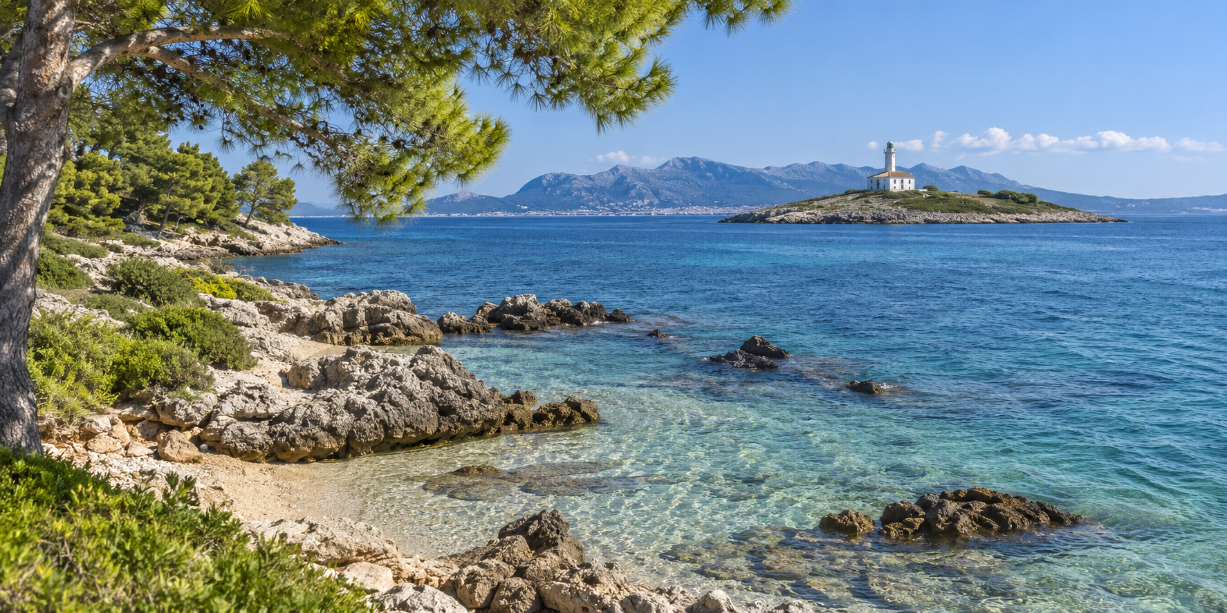 Côte d’Alcanada à Alcúdia avec eau cristalline, pins et phare sur son îlot face à Majorque